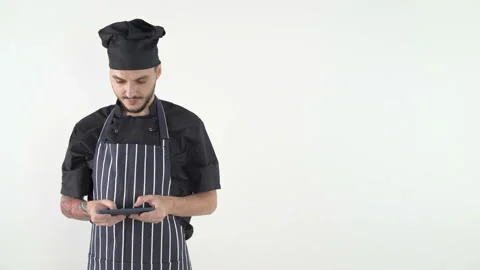 Chef in uniform and apron using smartphone Isolated on white background with cop Stock Footage 143635388