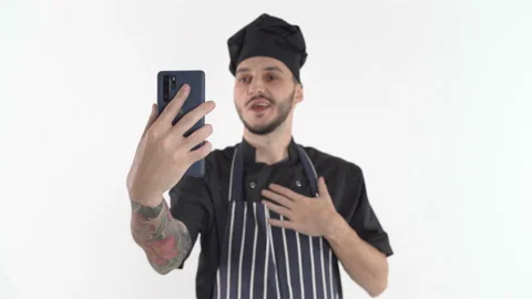 Chef in uniform doing video call or online class on smartphone holding it in Stock Footage 144253034