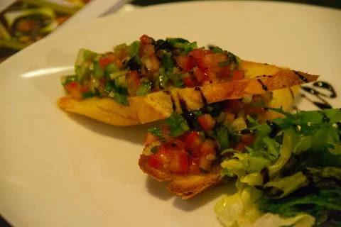 Chef in uniform in kitchen preparing buchetta and chikcen piccata Stock Photos