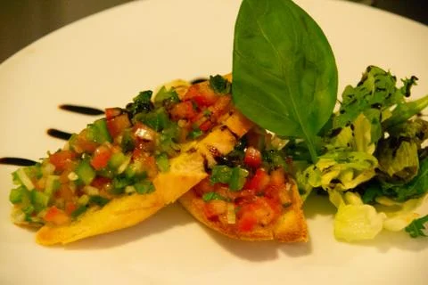 Chef in uniform in kitchen preparing buchetta and chikcen piccata Stock Photos