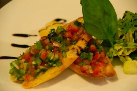 Chef in uniform in kitchen preparing buchetta and chikcen piccata Stock Photos