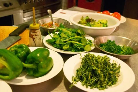 Chef in uniform in kitchen preparing buchetta and chikcen piccata Stock Photos