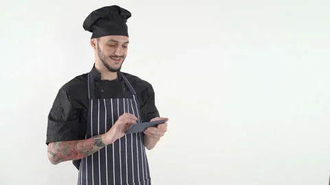 Chef in uniform typing on smartphone against white background Stock Footage 144920034