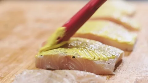 Chef use culinary brush to apply mustard on piece fish. Stock Footage 153457644