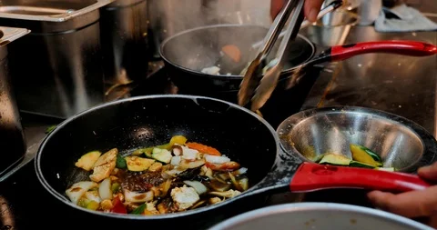 Chef use tong to remove cucumber or zucchini from asian stir fry spicy chicken. Stock Footage 119133263