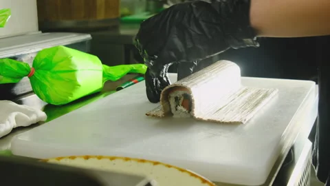 Chef uses bamboo mat to shape sushi roll ideally on table Video stock 324805133