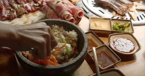 Chef uses a cast-iron pot for cooking rice, carefully mixes the rice with sliced Stock Footage 143904245