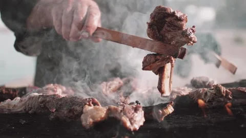 Chef uses a forceps to turn over smoky pork ribs cocking on barbecue 스톡 동영상 144815079