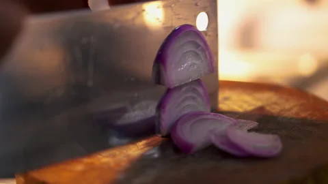 Chef uses a kitchen knife to slice fresh shallots on a wooden cutting board. Stock Footage 199749098