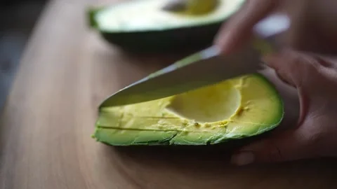 Chef uses knife to slice avocado pear Stock Footage 276294979