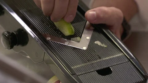 Chef uses mandolin slicer for vegetable Stock Footage 92059431