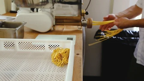 Chef uses a pasta cutting machine to make fresh spaghetti. 動画素材 95769697