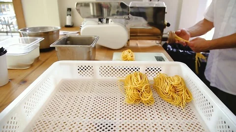 Chef uses a pasta cutting machine to make fresh spaghetti. Stock Footage 95770167