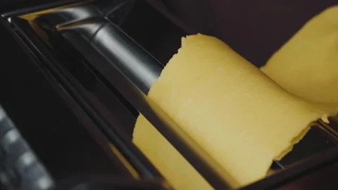 A chef uses a pasta machine and makes tagliatelle or lasagna Stock Footage 168876696
