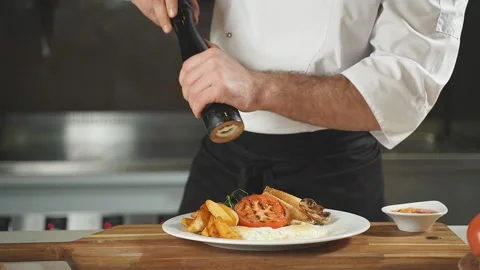 The chef uses a pepper mill to sprinkle the delicious dish before serving Stock Footage 149749403