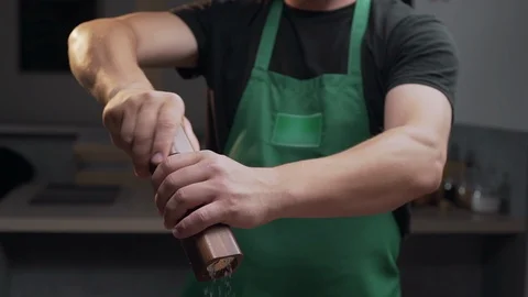 Chef uses salt mill to add some salt for his meal, salt falls in slow motion Stock Footage 114215861
