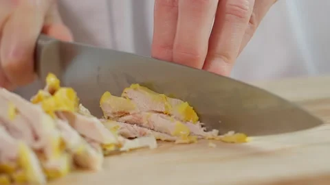 The chef uses a sharp knife to cut the boiled chicken breast into cubes Stock Footage 270146913