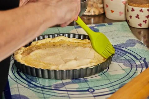 Chef uses special brush to brush the pie dough with egg before baking in the  Stock Photos