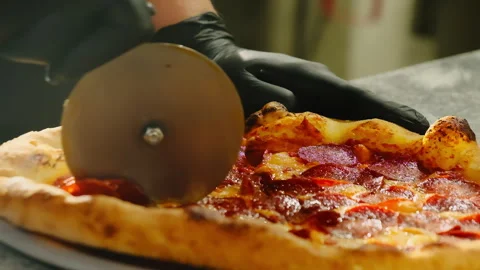 Chef uses specialized knife to divide pizza into portions Stock Footage 326369995