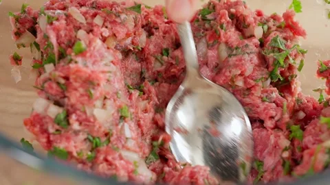 The chef uses a spoon to mix meat, minced beef with onions and herbs Stock Footage 265177059
