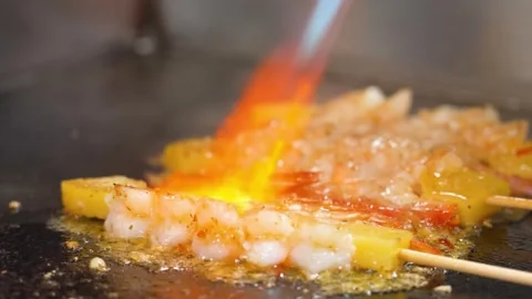 Chef Using Blowtorch to Caramelize Fresh Shrimp Skewers on a Hot Griddle Stock Footage 337440667