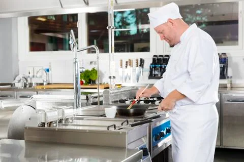 Chef using brush to prepare a dish in the kitchen Stock Photos