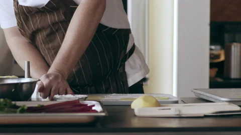 Chef using a circular ring to cut pieces of potatos in interior kitchen with sof Stock Footage 199463093