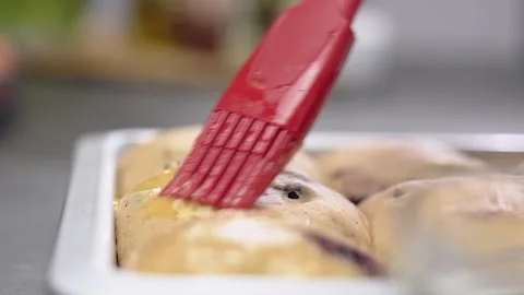 Chef using culinary brush to apply egg on Easter traditional hot cross buns. Vídeos de archivo 151046757