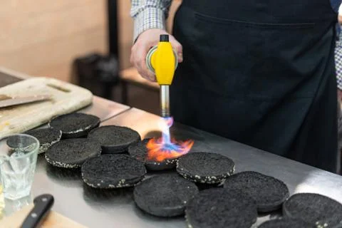 Chef using a culinary torch to make buns crispy Stock Photos