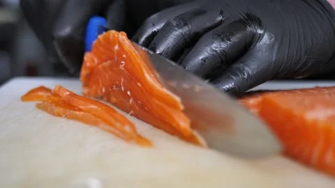 Chef using fish fillet knife slicing fresh salmon meat on cutting board in Video stock 291296702