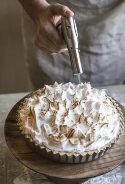 Chef using gas burner on lemon meringue pie Stock Photos