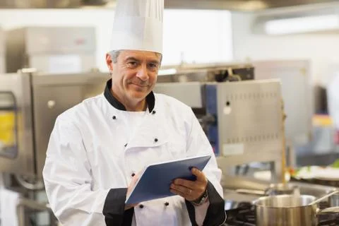 Chef using his digital tablet and looking at camera Stock Photos