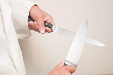 Chef using knife held in front of him Stock Photos
