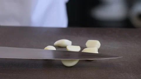 Chef using knife to smashing the fresh garlic on a cutting board. Stock Footage 271613716