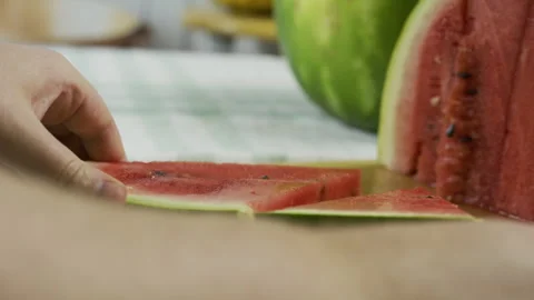 Chef using large knife to slice watermelon triangle into smaller ones - closeup Видео 341197502