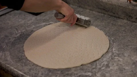 Chef Using Roller to Dock Pizza Dough – Preparing for Baking 動画素材 303225692