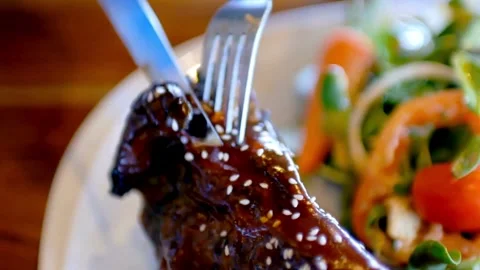 Chef using a sharp knife to slice a steak, ensuring each piece is tender 库存影片 336581653