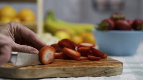 Chef using small knife to slice up strawberry on cutting board - closeup, Stock Footage 341186596