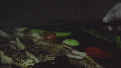 Chef using tongs to flip fresh fish on a grill 스톡 동영상 332076377