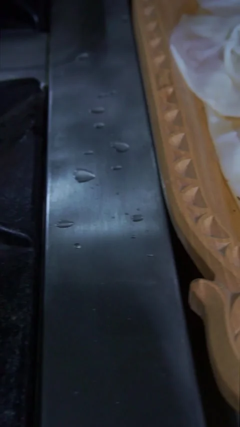 Chef using a wire skimmer to place the first boiled dough sheet into a carved wo Stock Footage 342627863