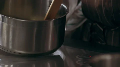 Chef using a wire spoon to transfer potatoes into hot oil in interior kitchen wi Stock Footage 199460823