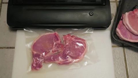 Chef Vacuum Packs Pork Chops Stock Footage 71595167