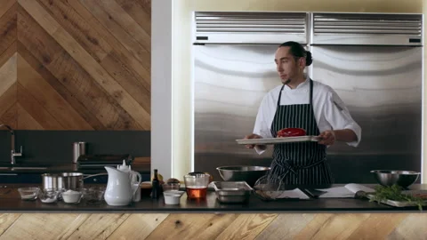 Chef walking with tray past other chefs and places it in oven in interior kitche Stock Footage 199463540