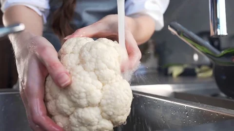 Chef washes cauliflower for vegetable ragout cooking, housewife cooks vegetables Stock Footage 73332941