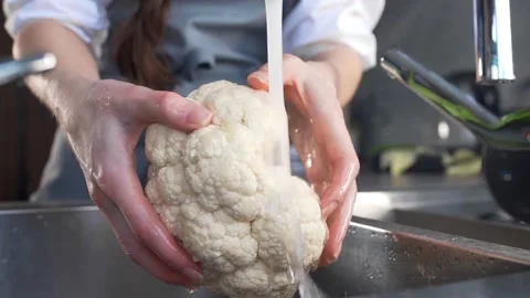 Chef washes cauliflower for vegetable ragout Stock Footage 143780255