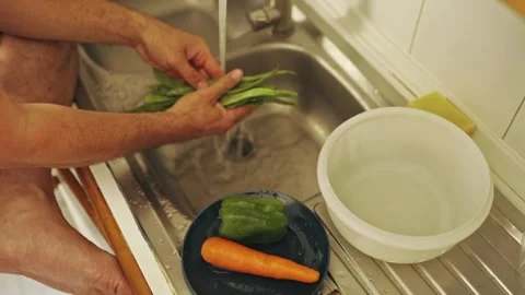 Chef washes fresh green beans for a healthy meal preparation Stock Footage 308033870