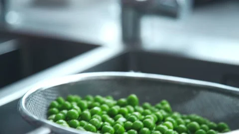 Chef washes green pea for vegetable ragout Stock Footage 143780235