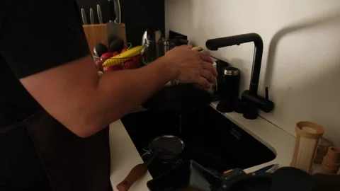 Chef washing and drying a stainless steel pan in a kitchen sink Stock Footage 340896442