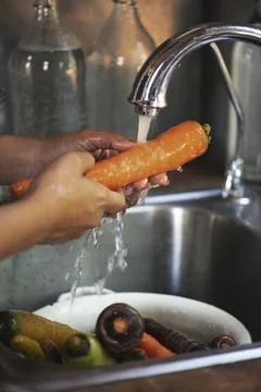 Chef washing a carrot in the sink Stock Photos