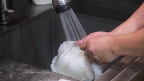 Chef Washing Fresh White Squid Under Running Tap Water in Kitchen Sink 動画素材 344218104